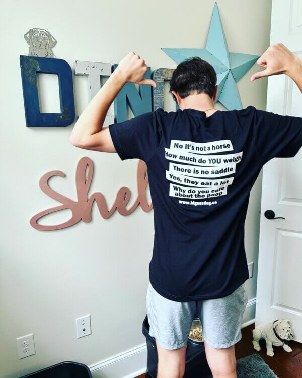 A young man modeling a t-shirt with the answers to the five most commonly asked questions about big dogs